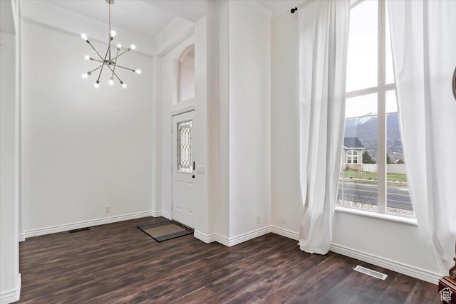 entryway with baseboards, visible vents, dark wood-type flooring, and a chandelier