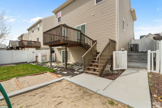 rear view of house featuring stairway, central air condition unit, a deck, a fenced backyard, and a patio