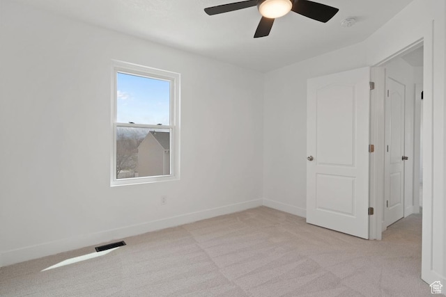 unfurnished room with light carpet, baseboards, ceiling fan, and visible vents
