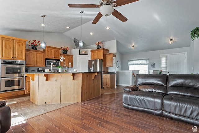 1288 S Pondside Dr, Saratoga Springs, UT 84045 - kitchen with wood finished floors, a ceiling fan, appliances with stainless steel finishes, open floor plan, and a breakfast bar area