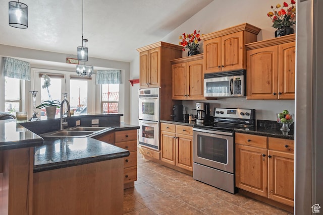 1288 S Pondside Dr, Saratoga Springs, UT 84045 - kitchen with a kitchen island with sink, stainless steel appliances, dark countertops, a sink, and decorative light fixtures