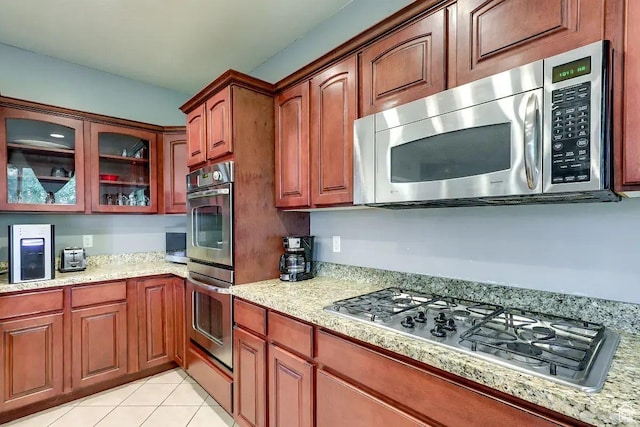 1784 W Grays Pl, Lehi, UT 84043 - kitchen with light tile patterned flooring, glass insert cabinets, light stone counters, and stainless steel appliances