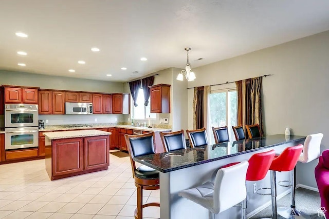 1784 W Grays Pl, Lehi, UT 84043 - kitchen featuring recessed lighting, a breakfast bar, light tile patterned flooring, a kitchen island, and appliances with stainless steel finishes