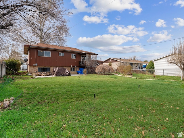back of house featuring fence and a lawn