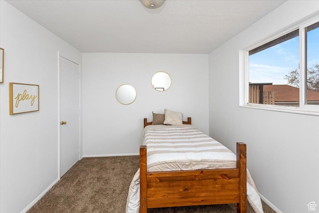 bedroom featuring carpet flooring, baseboards, and a textured ceiling