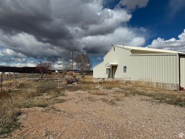 6051 N 11500 E, Lapoint, UT 84039 - view of home's exterior featuring board and batten siding, an outbuilding, and fence