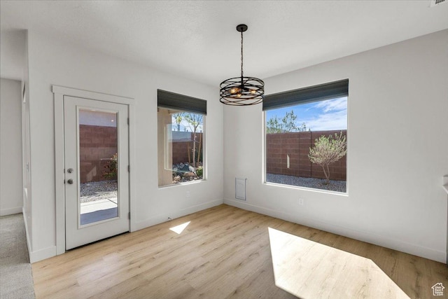 3150 Fuchsia Dr, St George, UT 84790 - unfurnished dining area featuring a wealth of natural light, a notable chandelier, and wood finished floors