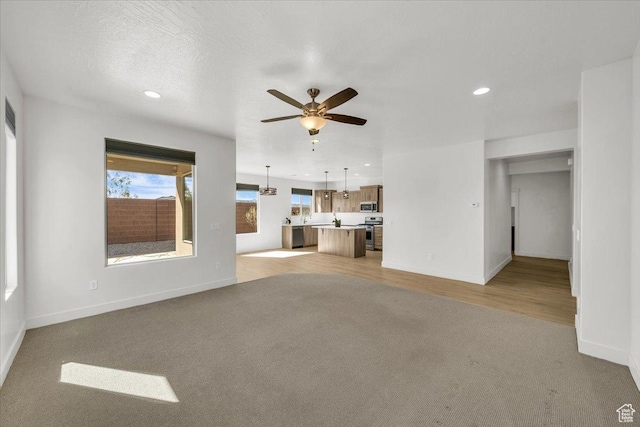 3150 Fuchsia Dr, St George, UT 84790 - unfurnished living room featuring baseboards, recessed lighting, light colored carpet, and a ceiling fan