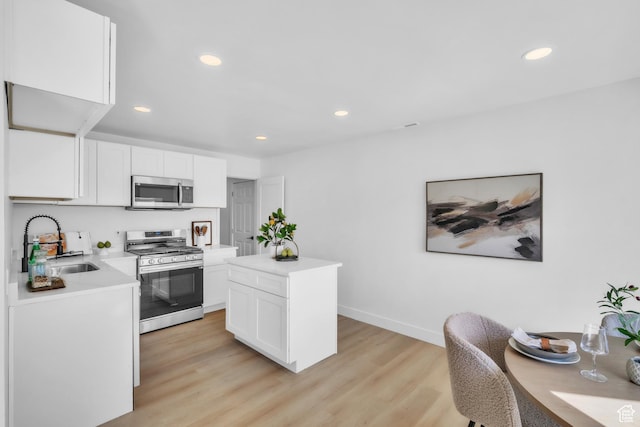 4970 S 4720 W, Salt Lake City, UT 84118 - kitchen featuring white cabinetry, light countertops, a sink, light wood-style flooring, and appliances with stainless steel finishes