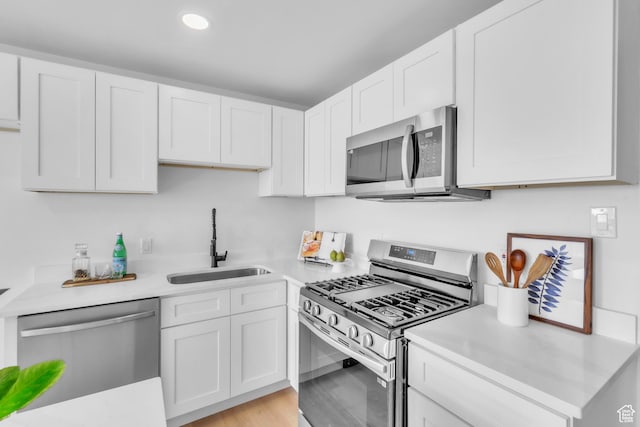 4970 S 4720 W, Salt Lake City, UT 84118 - kitchen featuring light countertops, a sink, white cabinetry, appliances with stainless steel finishes, and light wood-style flooring