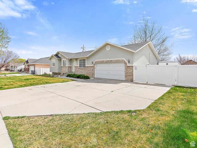 ranch-style home featuring a gate, a garage, a front yard, brick siding, and stucco siding