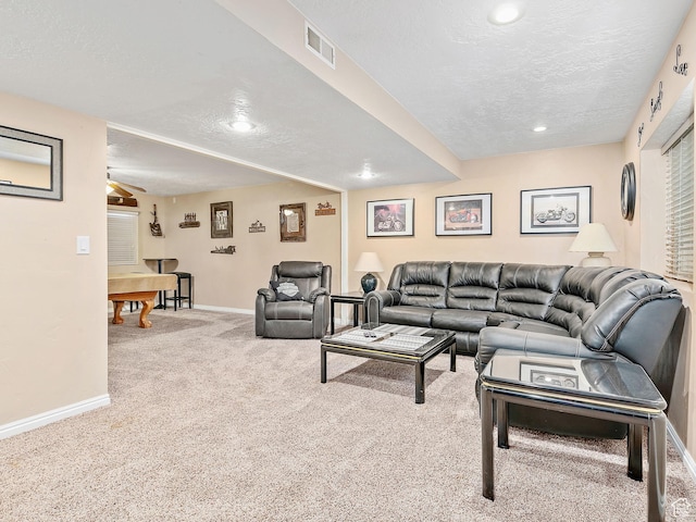 living area with baseboards, visible vents, carpet floors, and a textured ceiling