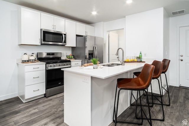 3440 W Mitchell Dr, Lehi, UT 84043 - kitchen with a sink, a breakfast bar area, stainless steel appliances, visible vents, and dark wood-style flooring