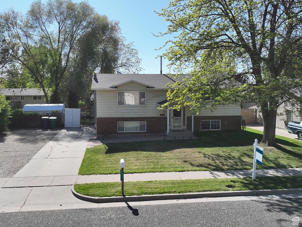 6073 S 2850 W, Roy, UT 84067 - view of front of home featuring a front yard, brick siding, and concrete driveway