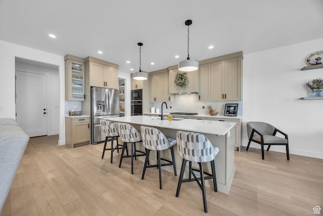 2119 N 520 W, Centerville, UT 84014 - kitchen featuring tasteful backsplash, light wood-type flooring, light countertops, a breakfast bar, and stainless steel appliances