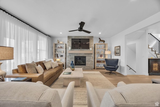 2119 N 520 W, Centerville, UT 84014 - living room featuring light wood finished floors, a fireplace, a ceiling fan, baseboards, and stairway