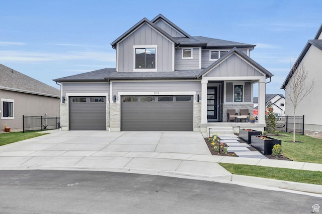 view of front of house with concrete driveway, fence, board and batten siding, a porch, and a garage