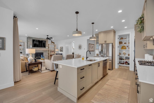 2119 N 520 W, Centerville, UT 84014 - kitchen with a stone fireplace, a sink, light countertops, stainless steel appliances, and light wood-style flooring