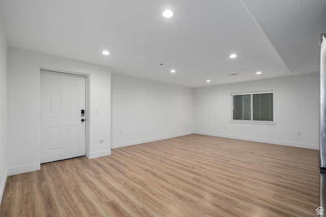 empty room featuring baseboards, light wood-style flooring, and recessed lighting