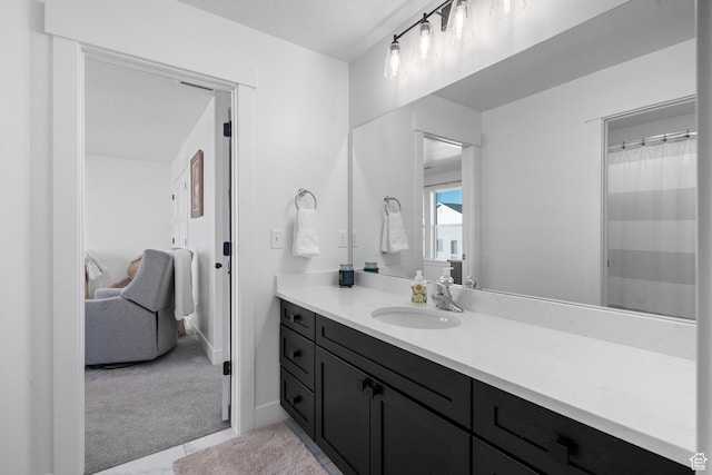 ensuite bathroom with ensuite bathroom, baseboards, and vanity