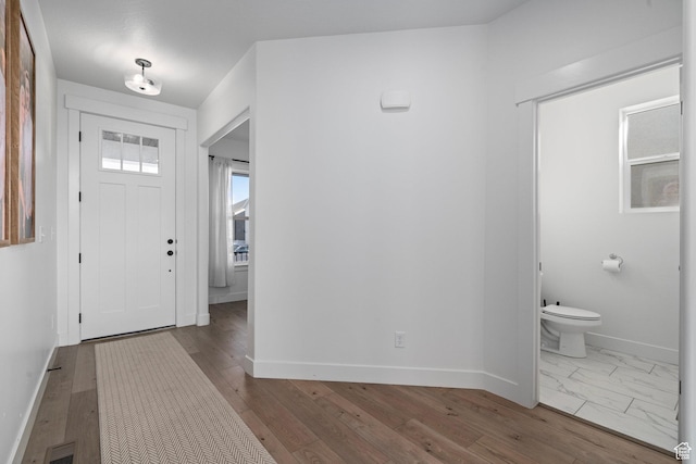 foyer featuring baseboards, visible vents, and hardwood / wood-style flooring
