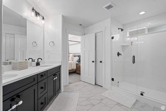ensuite bathroom featuring marble finish floor, visible vents, a sink, and a stall shower