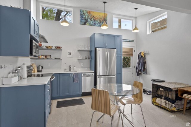 67 W 300 S, Kanab, UT 84741 - kitchen with a wealth of natural light, light countertops, open shelves, blue cabinets, and appliances with stainless steel finishes