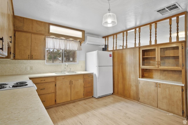 67 W 300 S, Kanab, UT 84741 - kitchen with light countertops, visible vents, a sink, an AC wall unit, and freestanding refrigerator