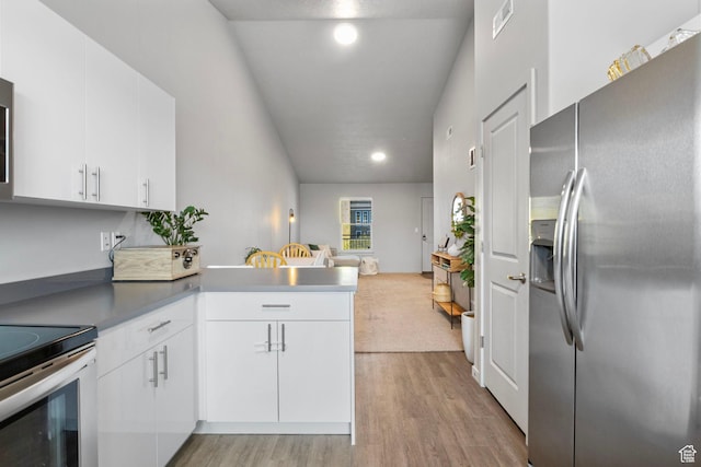 kitchen with open floor plan, light wood-type flooring, white cabinets, a peninsula, and appliances with stainless steel finishes