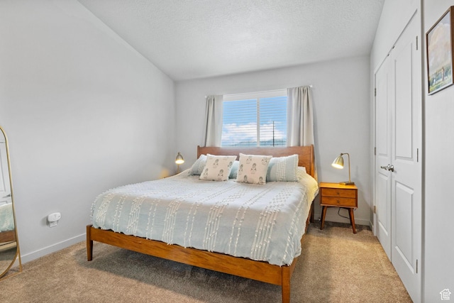 bedroom with carpet floors, a closet, baseboards, and a textured ceiling
