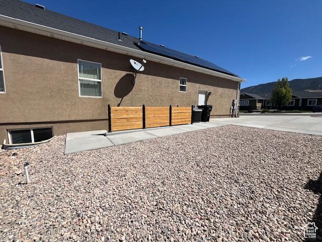 2367 N Monarch Cir E, Cedar City, UT 84721 - rear view of house with solar panels, fence, and stucco siding