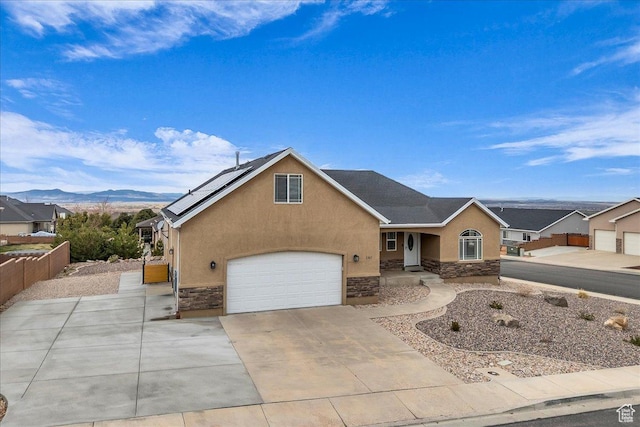 2367 N Monarch Cir E, Cedar City, UT 84721 - view of front of home featuring stone siding, stucco siding, an attached garage, a mountain view, and driveway