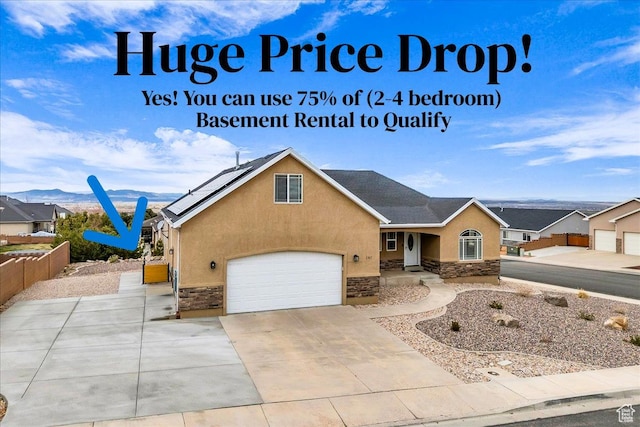 2367 N Monarch Cir E, Cedar City, UT 84721 - view of front of home featuring stone siding, stucco siding, a garage, and driveway