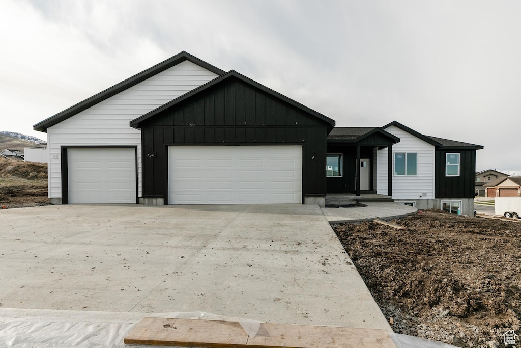 1164 E 30 S, Smithfield, UT 84335 - view of front facade with board and batten siding, a garage, and concrete driveway