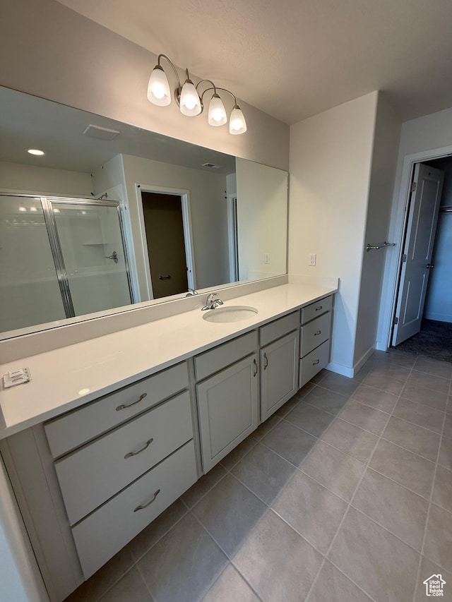 bathroom with a shower stall, baseboards, tile patterned flooring, and vanity