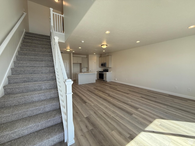 stairs featuring recessed lighting, baseboards, and wood finished floors