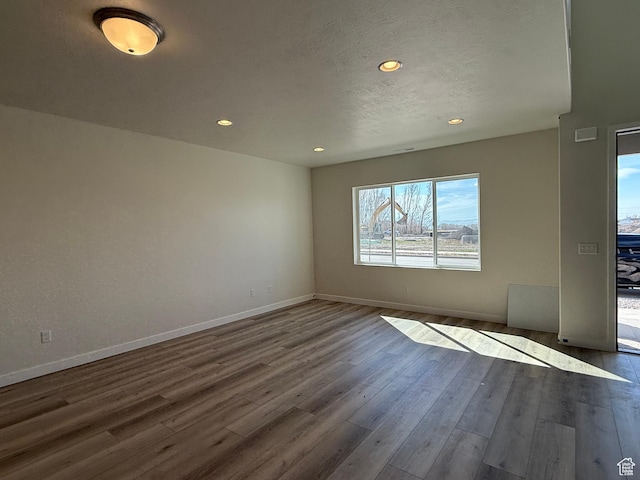unfurnished room with dark wood-style floors, baseboards, and recessed lighting