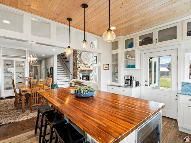 129 S 7200 E, Huntsville, UT 84317 - dining room with a notable chandelier, dark wood-style flooring, a stone fireplace, wood ceiling, and stairway