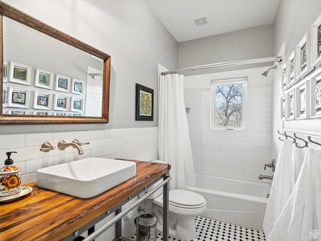 129 S 7200 E, Huntsville, UT 84317 - bathroom featuring visible vents, a sink, tile walls, shower / tub combo with curtain, and toilet