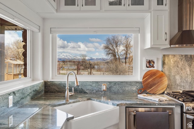 129 S 7200 E, Huntsville, UT 84317 - kitchen featuring glass insert cabinets, white cabinets, a sink, wall chimney range hood, and appliances with stainless steel finishes
