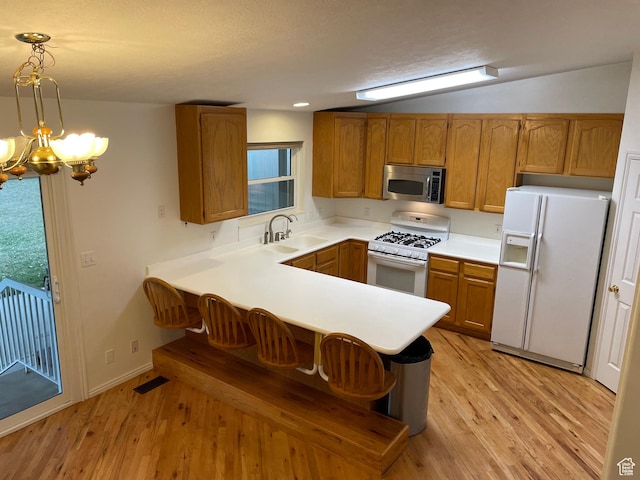 567 S Hazel Dr, Salem, UT 84653 - kitchen with white appliances, a sink, brown cabinetry, a peninsula, and light wood-style flooring