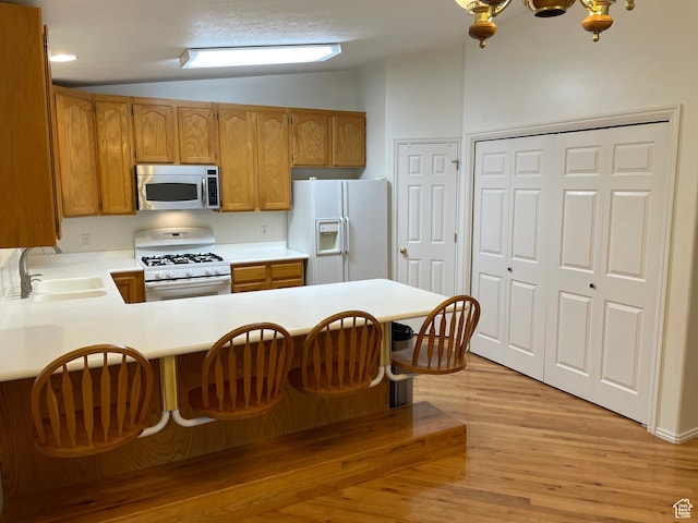567 S Hazel Dr, Salem, UT 84653 - kitchen with white appliances, a sink, vaulted ceiling, light countertops, and light wood-style floors