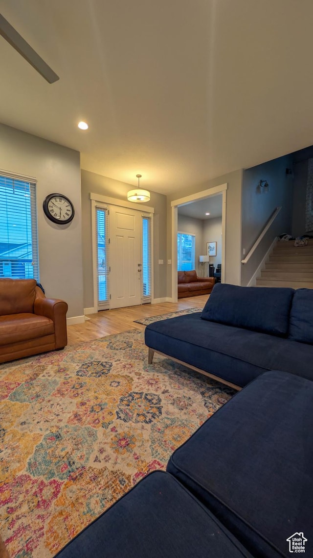 living room featuring wood finished floors, baseboards, stairway, and recessed lighting
