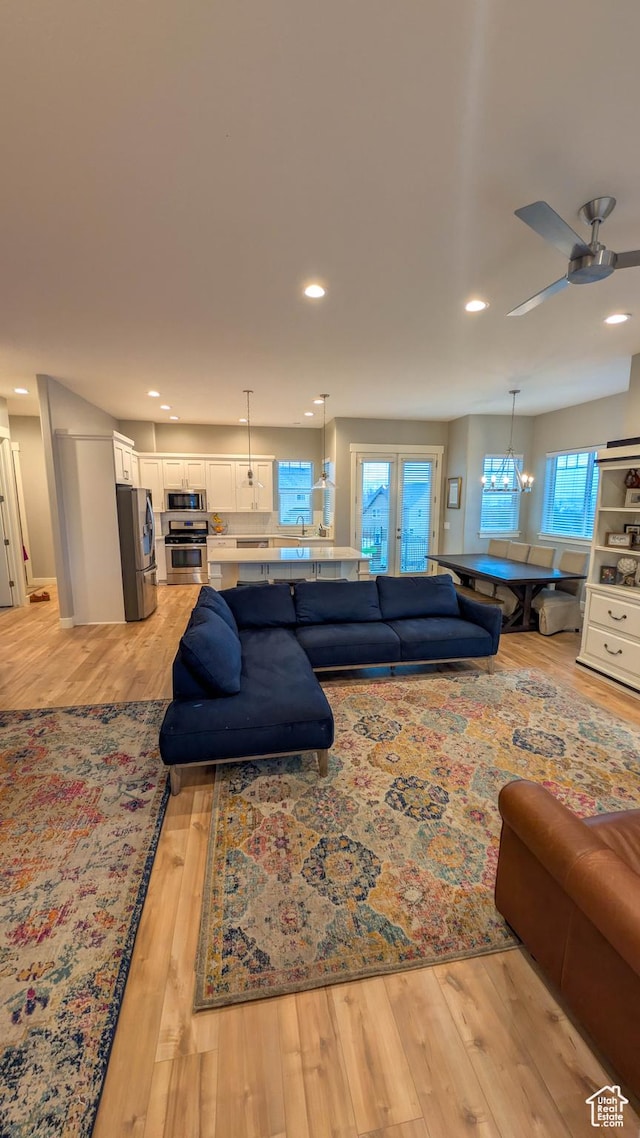 living room with light wood finished floors, ceiling fan, and recessed lighting