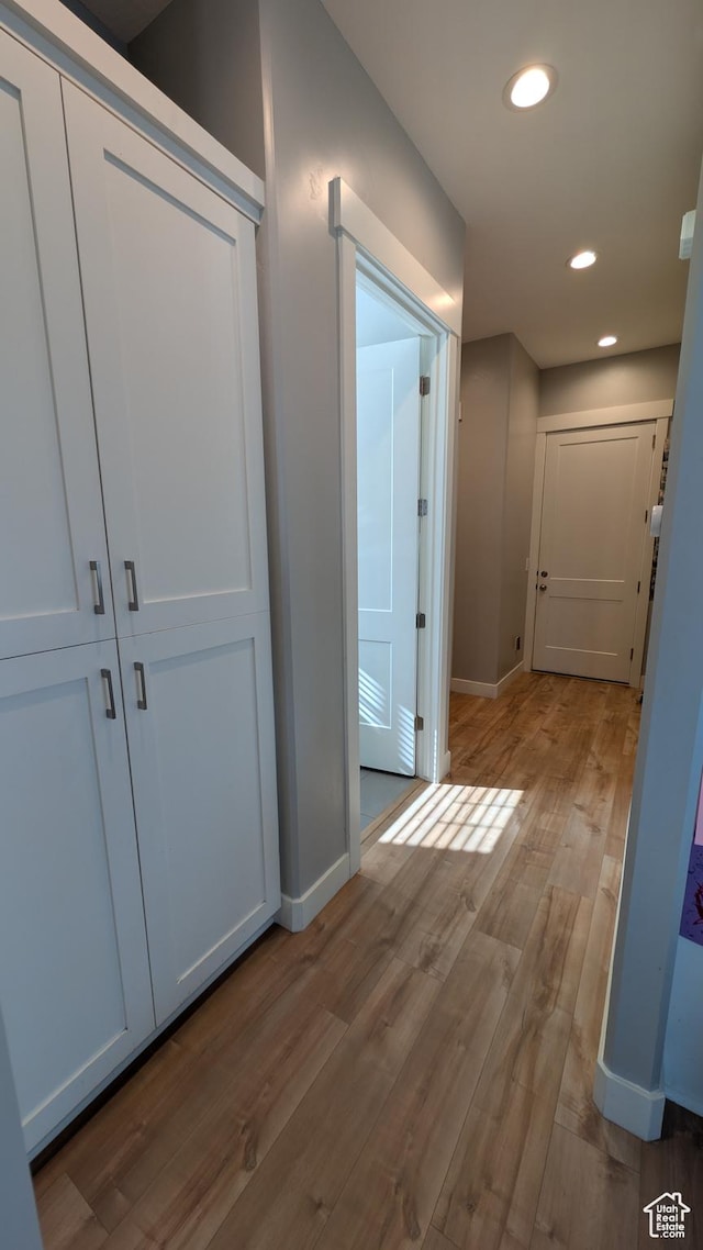 hall featuring recessed lighting, baseboards, and wood finished floors