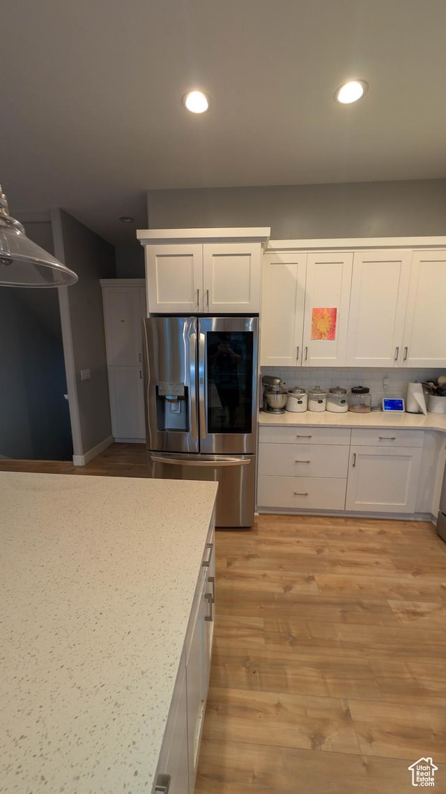 kitchen with white cabinetry, stainless steel fridge, recessed lighting, decorative backsplash, and light wood-style flooring