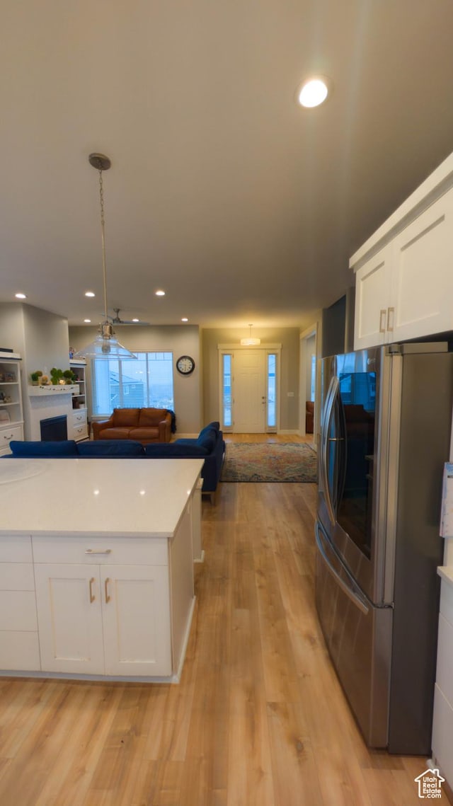 kitchen featuring smart refrigerator, white cabinetry, light wood finished floors, and open floor plan