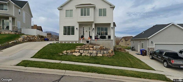 view of front of property with concrete driveway and a front yard