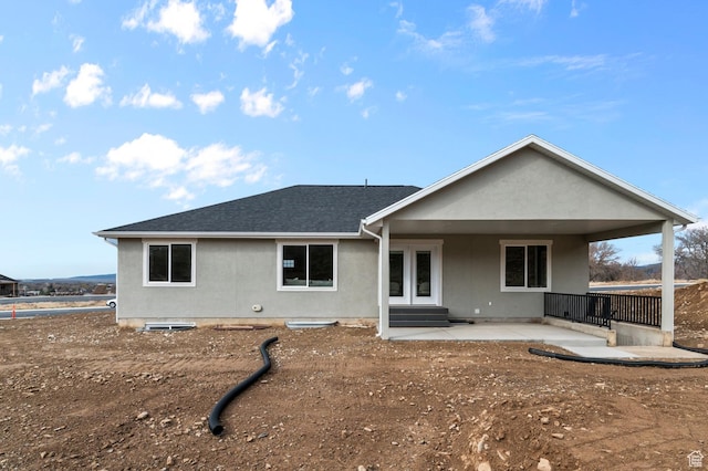 rear view of house featuring a patio, roof with shingles, french doors, and entry steps