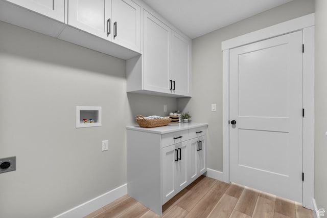 laundry room with light wood-style flooring, electric dryer hookup, washer hookup, and cabinet space